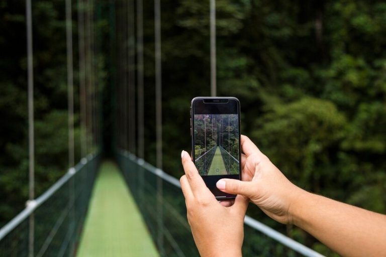 foto-toma-mano-humana-puente-colgante-telefono-celular-selva-tropical-costa-rica_23-2148248806